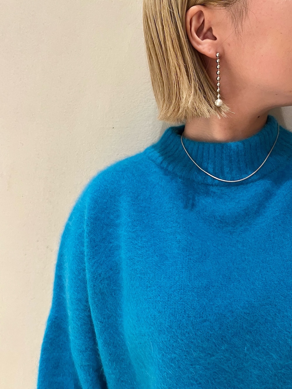 ブルー系のニット/セーター、ブラック系のその他パンツ、ブラック系のブーツを着用したレディースの秋コーディネートの10枚目の写真