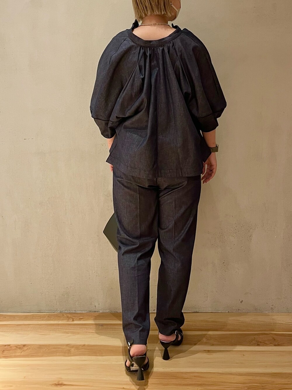 ブラック系のハンドバッグ、ブラック系のサンダル、ブルー系のブルゾンを着用したレディースの春コーディネートの3枚目の写真