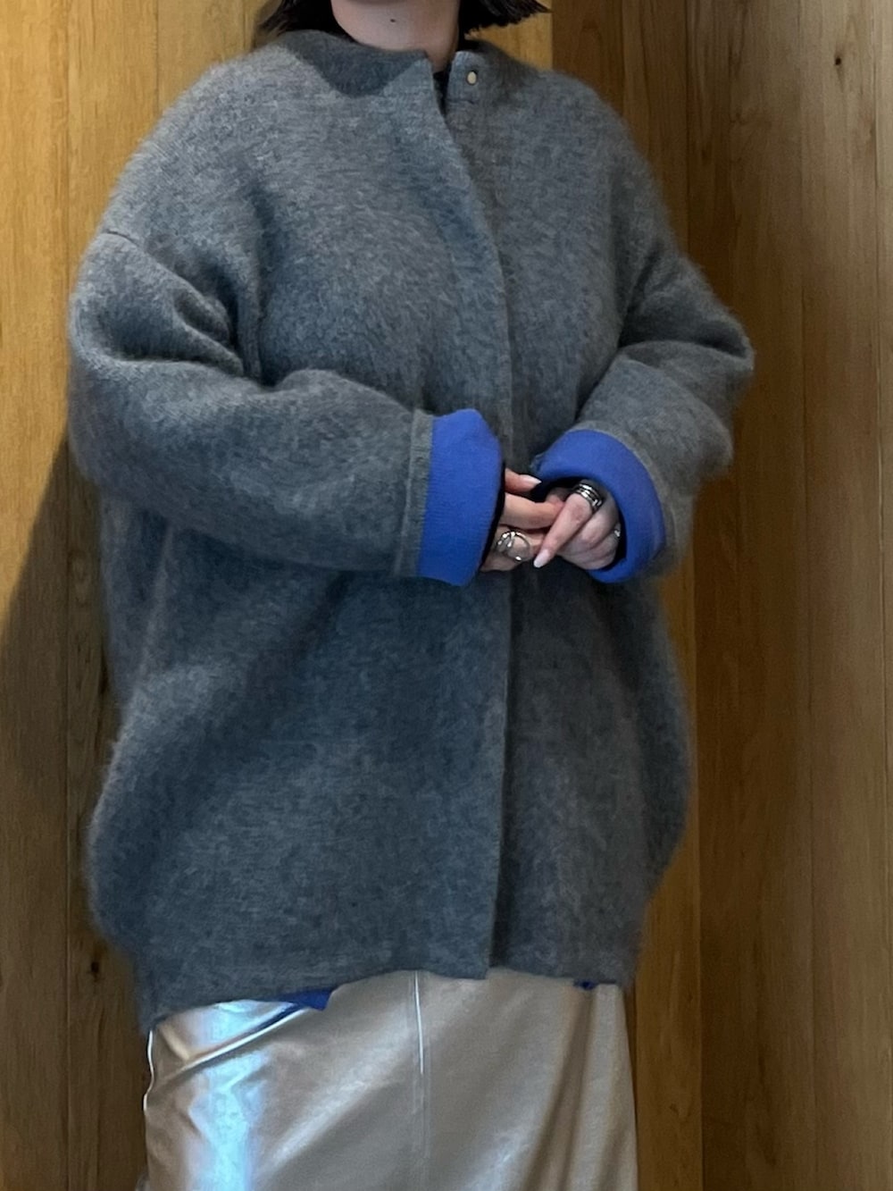 グレー系のカーディガン/ボレロ、シルバー系のスカート、ブラック系のブーツを着用したレディースの秋コーディネートの5枚目の写真