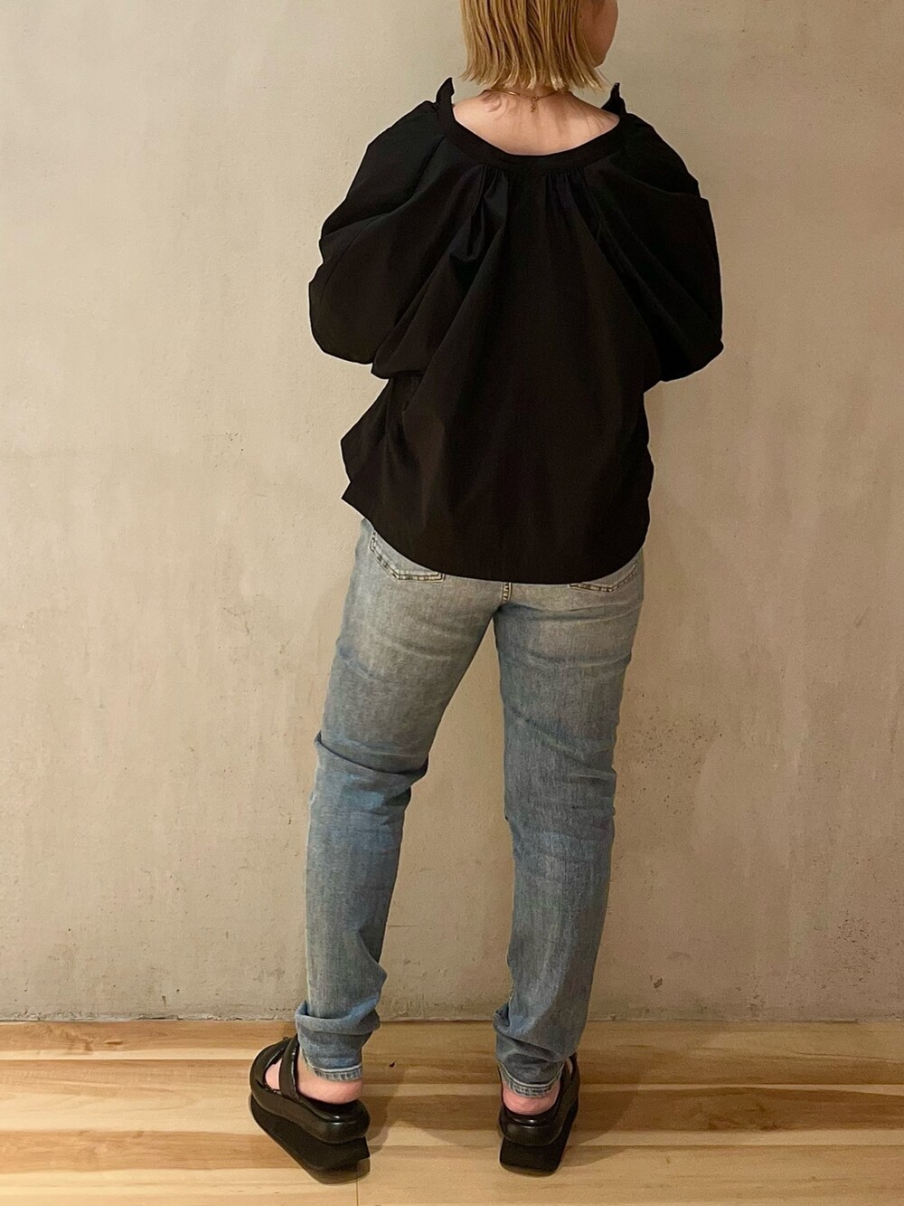 ブラック系のブルゾン、グリーン系のタンクトップ、ブルー系のデニムパンツを着用したレディースの夏コーディネートの3枚目の写真