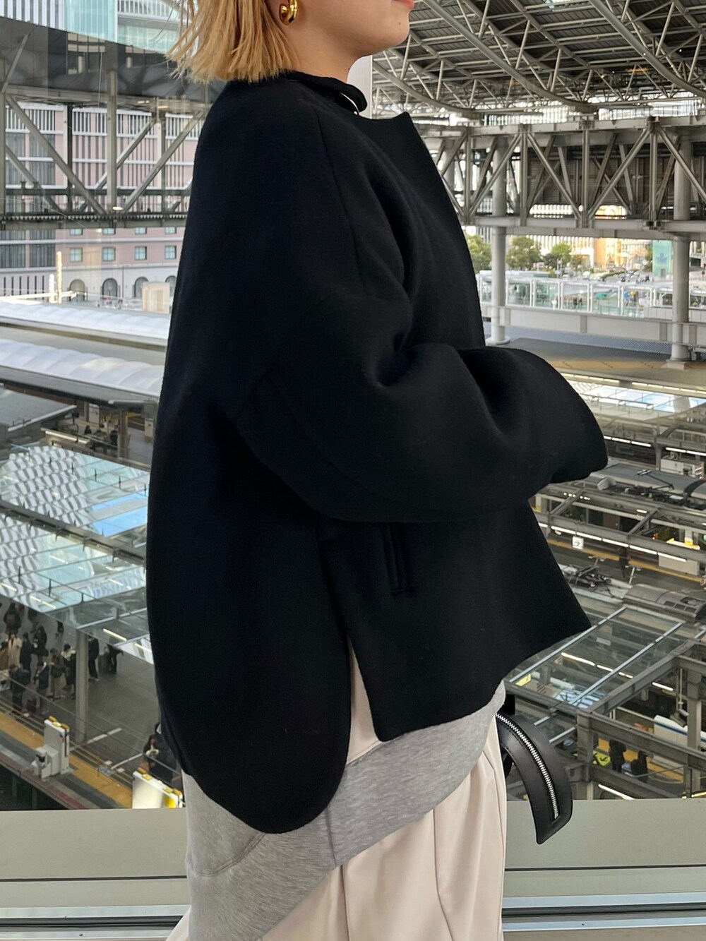 ブラック系のノーカラージャケット、グレー系のワンピース、ブラック系のハンドバッグを着用したレディースの冬コーディネートの5枚目の写真