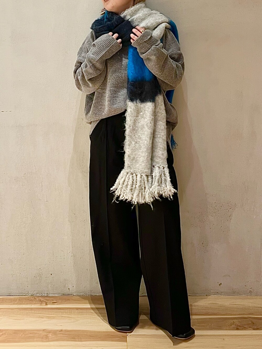 グレー系のニット/セーター、ブラック系のその他パンツ、ブラック系のブーツを着用したレディースの秋コーディネートの2枚目の写真