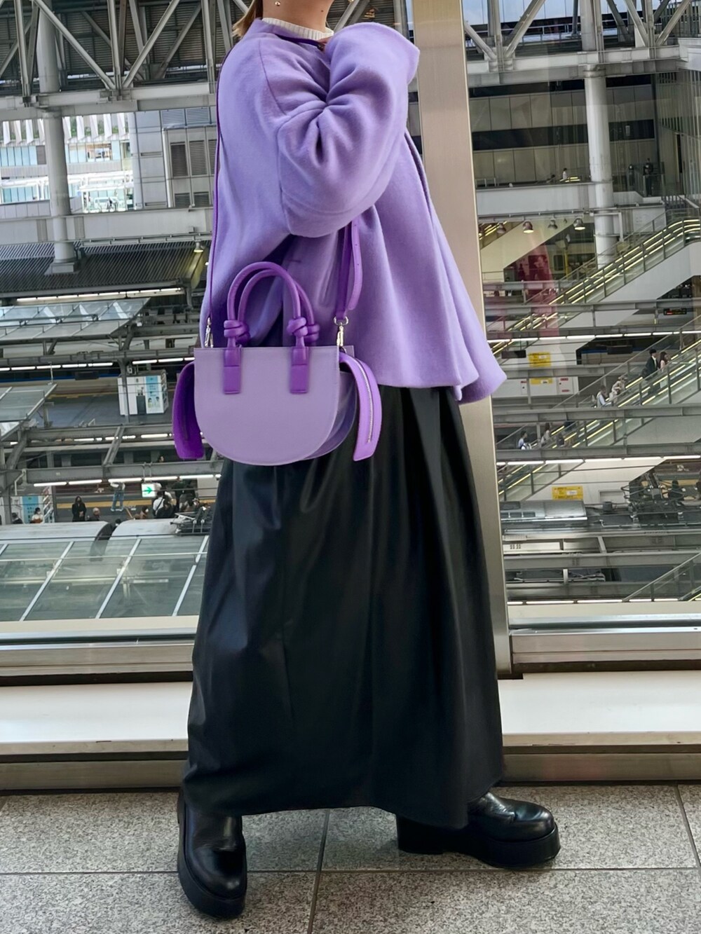 パープル系のノーカラージャケット、ブラック系のジャンパースカート、ホワイト系のニット/セーターを着用したレディースの秋コーディネートの4枚目の写真