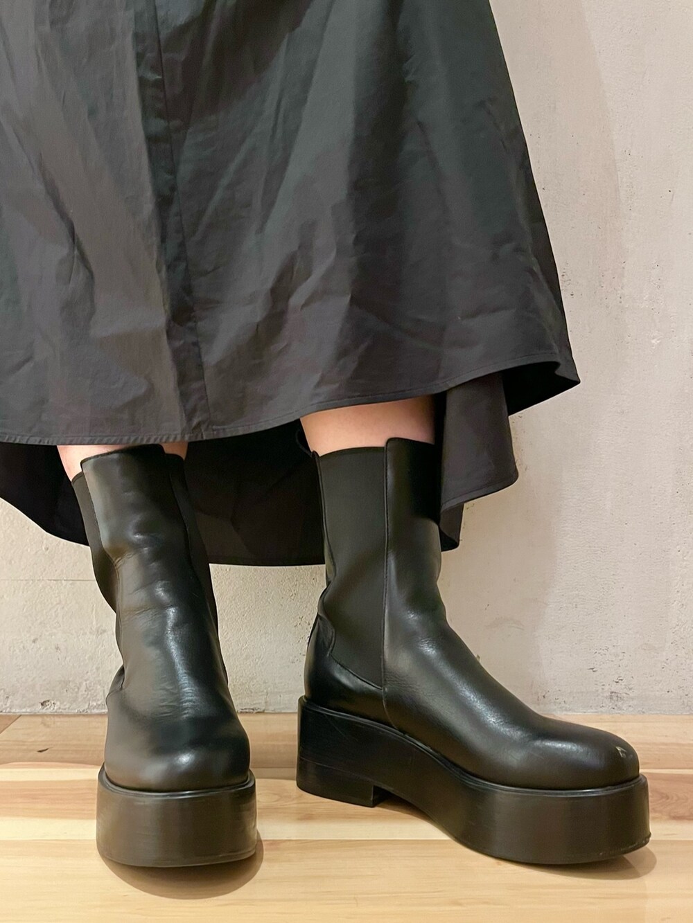 ブラック系のワンピース、ブラック系のブーツを着用したレディースの春コーディネートの7枚目の写真