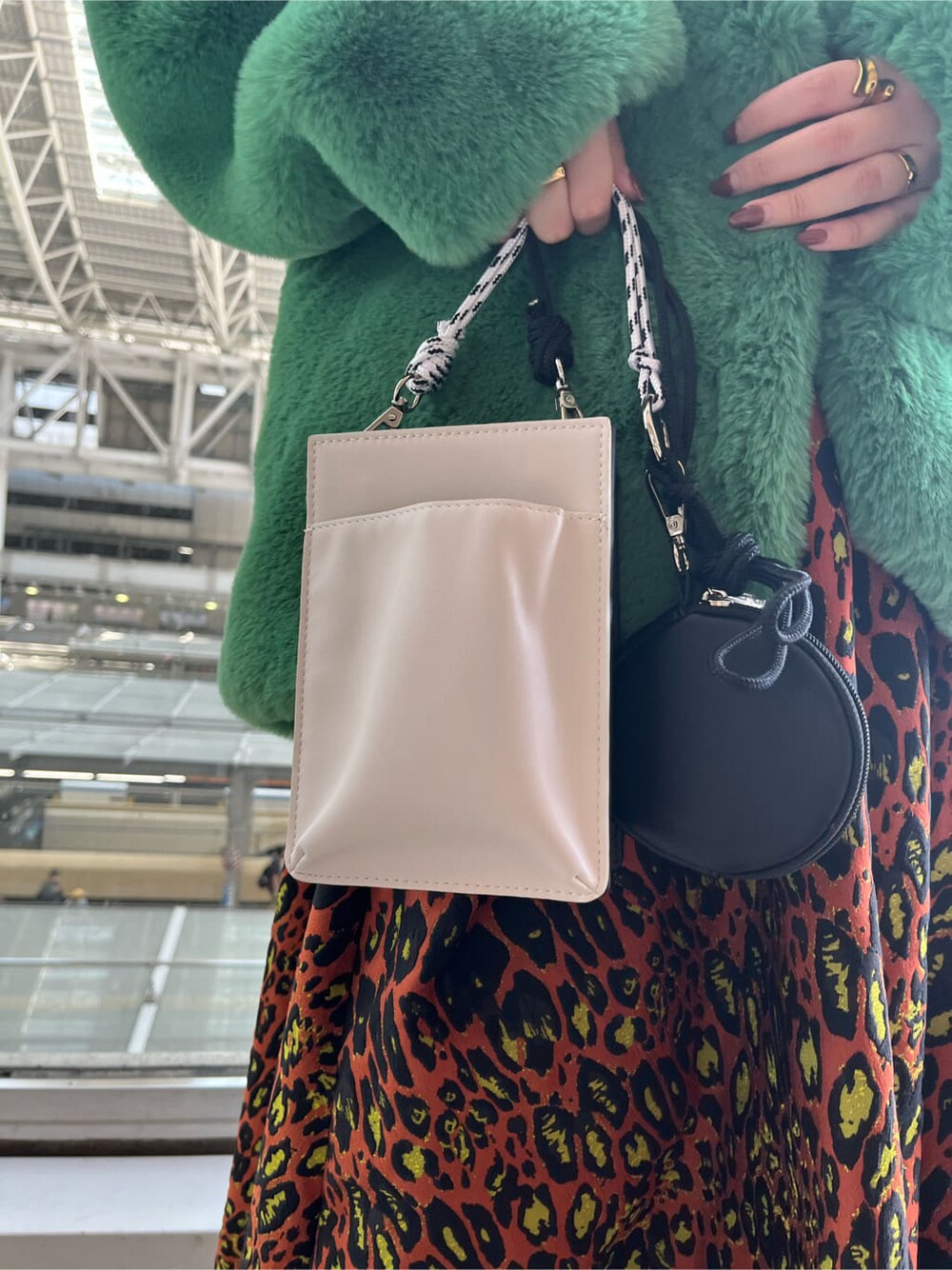 ブラック系のニット/セーター、ホワイト系のショルダーバッグ、グリーン系のノーカラーコートを着用したレディースの夏コーディネートの9枚目の写真