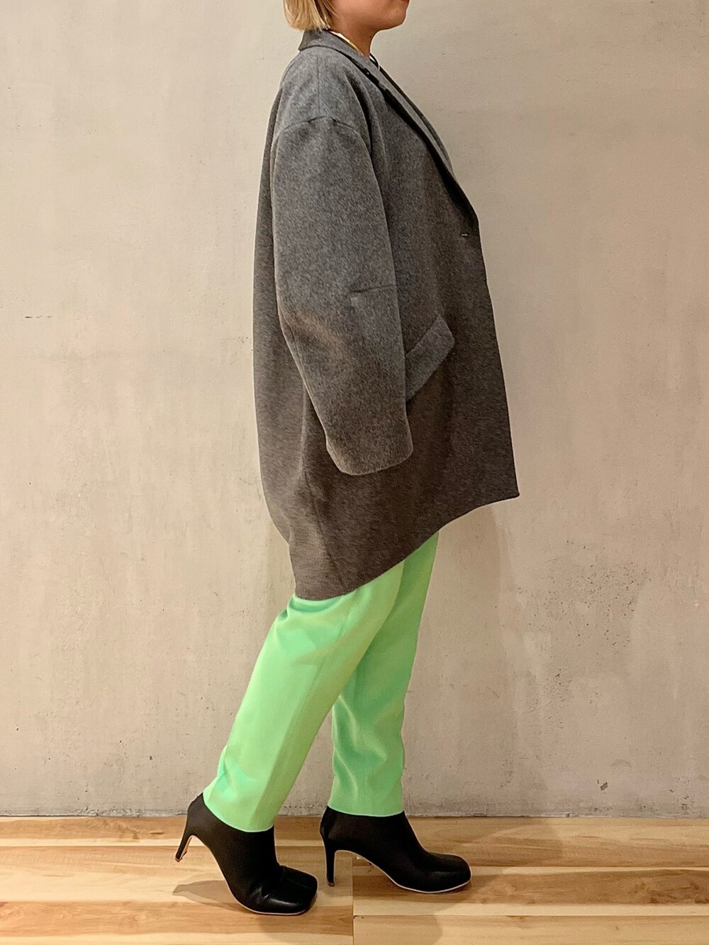 グレー系のチェスターコート、グリーン系のその他パンツ、シルバー系のTシャツ/カットソーを着用したレディースの秋コーディネートの2枚目の写真