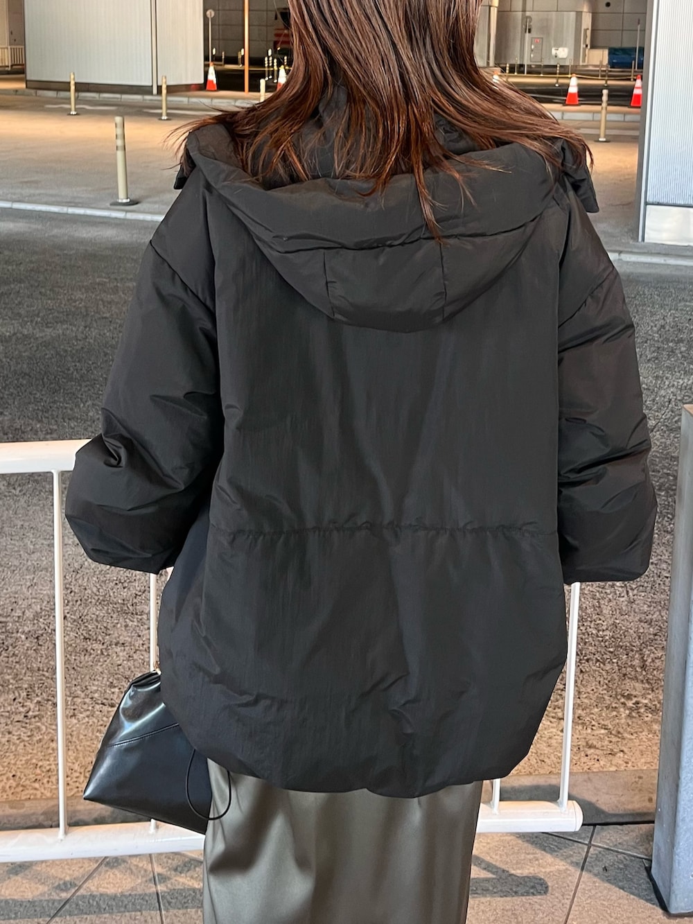 ブラック系のダウンジャケット/コート、ブラウン系のニット/セーター、ブラウン系のスカートを着用したレディースの冬コーディネートの6枚目の写真