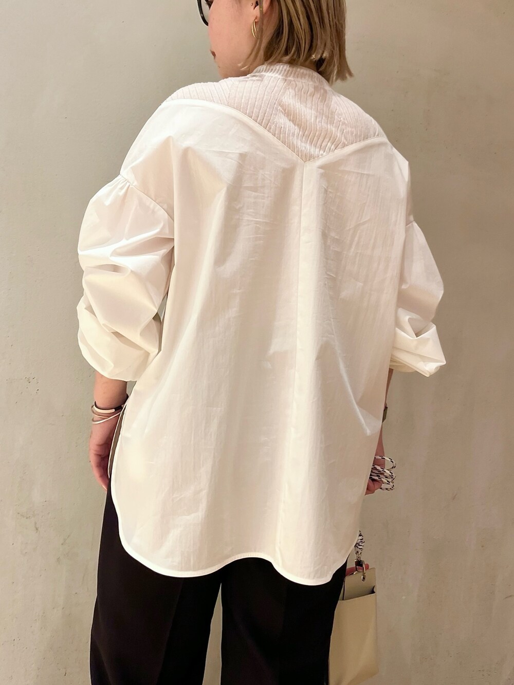 ベージュ系のショルダーバッグ、ブラック系のスニーカー、ブラック系のその他パンツを着用したレディースの冬コーディネートの6枚目の写真