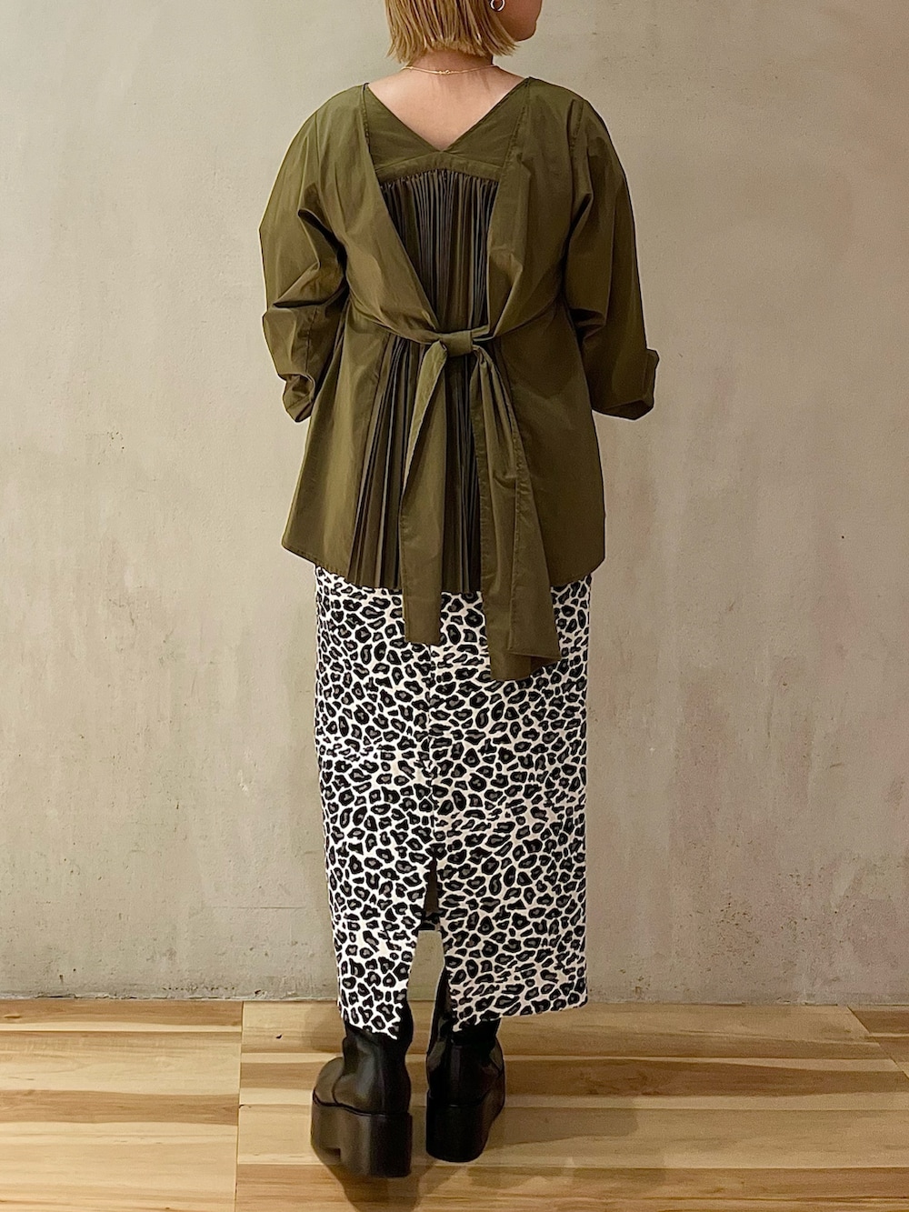 グリーン系のシャツ/ブラウス、ホワイト系のスカート、ブラック系のブーツを着用したレディースの秋コーディネートの2枚目の写真