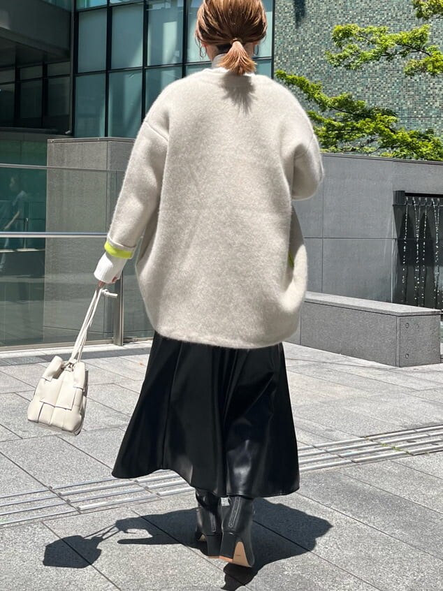 ブラック系のスカート、ホワイト系のニット/セーター、ホワイト系のカーディガン/ボレロを着用したレディースの夏コーディネートの3枚目の写真