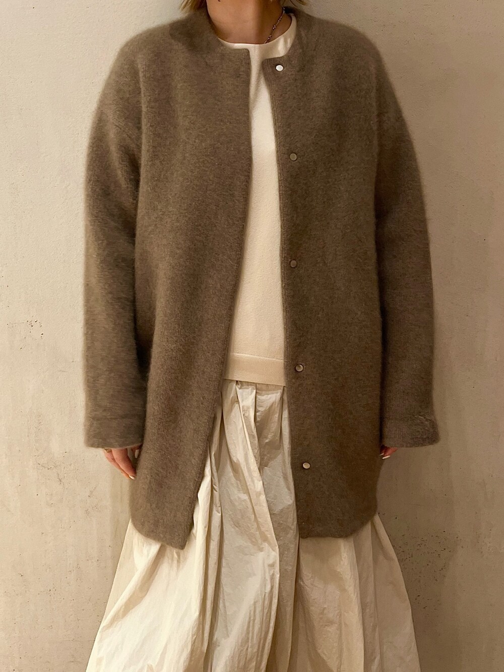 ベージュ系のノーカラージャケット、ベージュ系のワンピース、ブラック系のブーツを着用したレディースの夏コーディネートの4枚目の写真