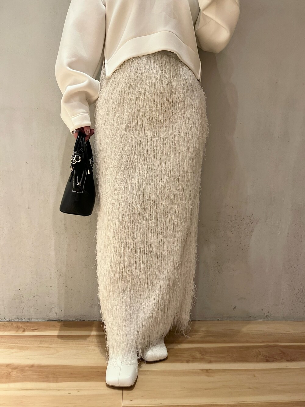 ホワイト系のTシャツ/カットソー、ホワイト系のスカート、ホワイト系のブーツを着用したレディースの春コーディネートの7枚目の写真