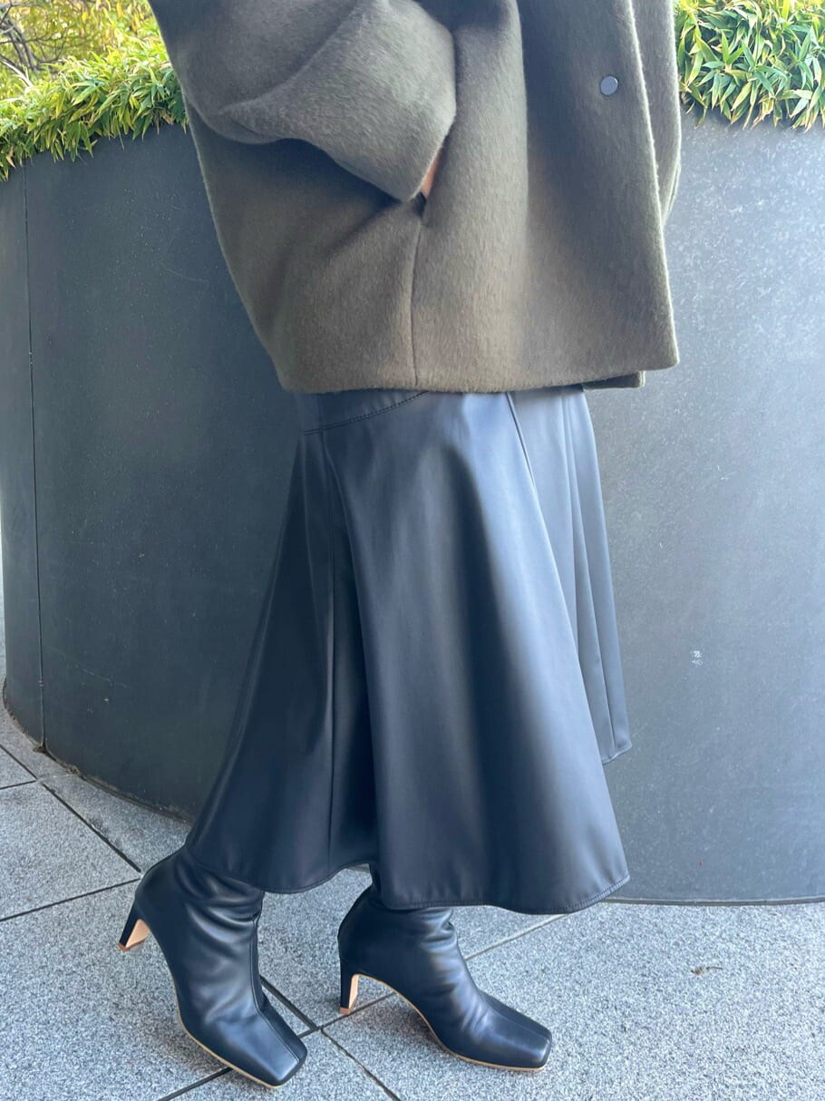 ブラック系のスカート、ブラック系のブーツ、グリーン系のノーカラーコートを着用したレディースの秋コーディネートの9枚目の写真