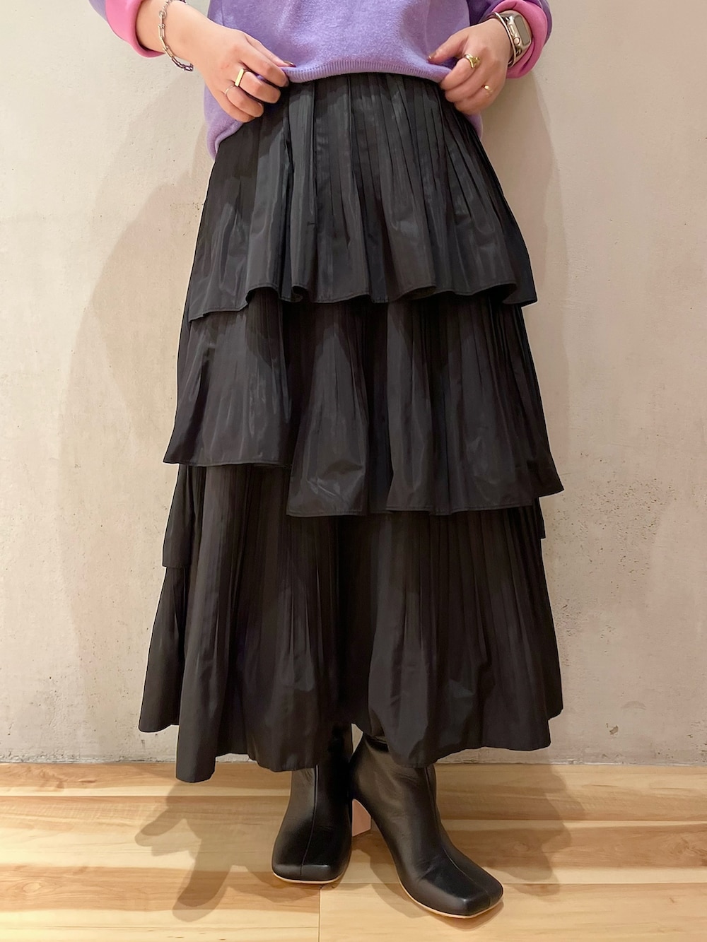 ホワイト系のダウンジャケット/コート、パープル系のニット/セーター、ブラック系のスカートを着用したレディースの夏コーディネートの9枚目の写真