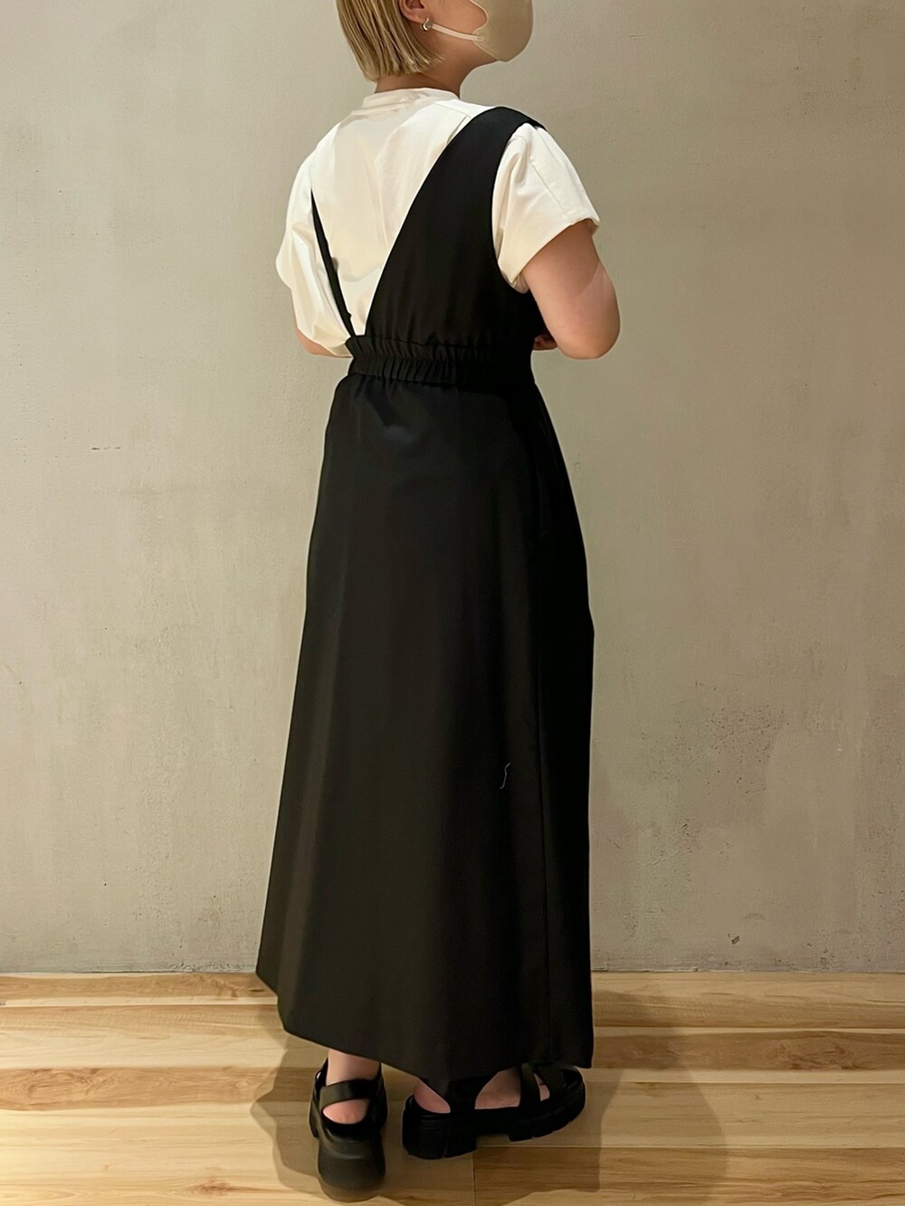 ホワイト系のTシャツ/カットソー、ブラック系のジャンパースカート、シルバー系のネックレスを着用したレディースの春コーディネートの2枚目の写真