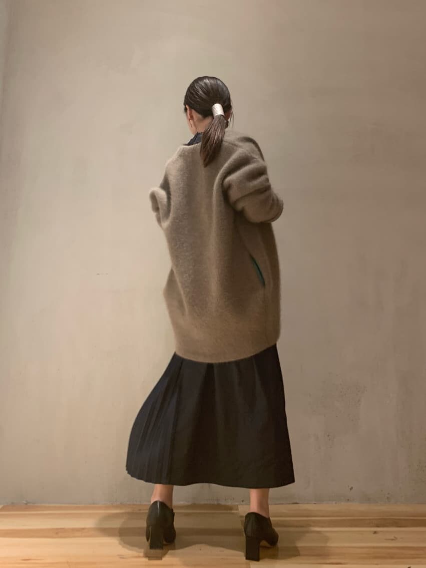 ブラック系のワンピース、ブラック系のブーツ、ベージュ系のカーディガン/ボレロを着用したレディースの秋コーディネートの2枚目の写真