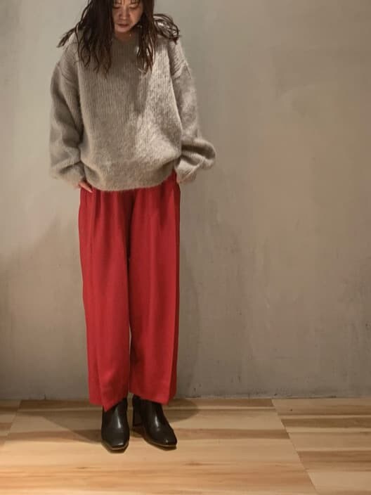 ブラック系のブーツ、ベージュ系のニット/セーター、レッド系のその他パンツを着用したレディースの秋コーディネートの4枚目の写真