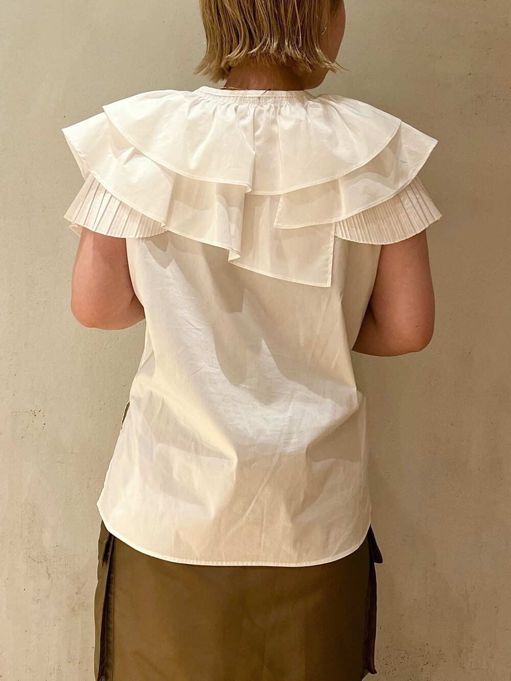 ホワイト系のシャツ/ブラウス、ブラウン系のスカート、ブラック系のブーツを着用したレディースの春コーディネートの6枚目の写真