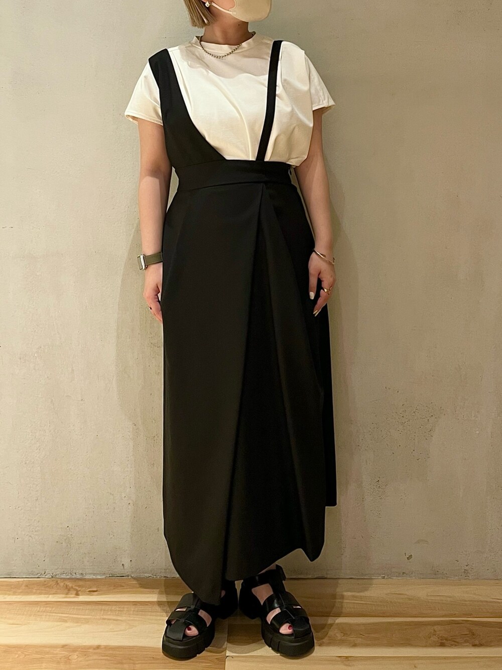 ホワイト系のTシャツ/カットソー、ブラック系のジャンパースカート、シルバー系のネックレスを着用したレディースの春コーディネートの3枚目の写真