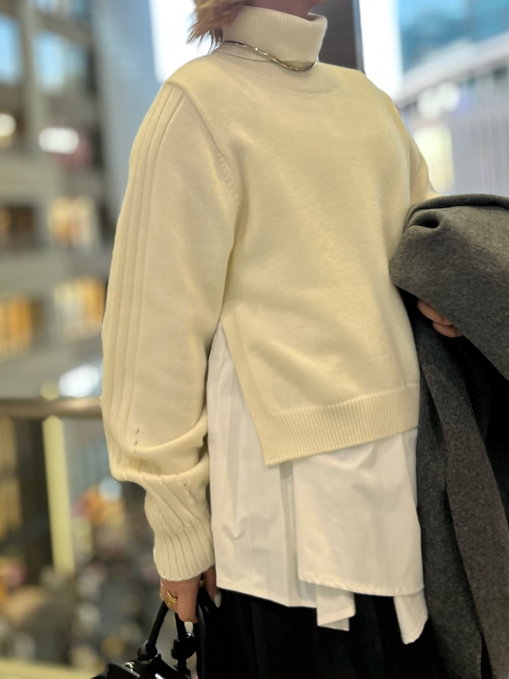 ブラック系のスカート、ブラック系のブーツ、ブラック系のハンドバッグを着用したレディースの冬コーディネートの8枚目の写真