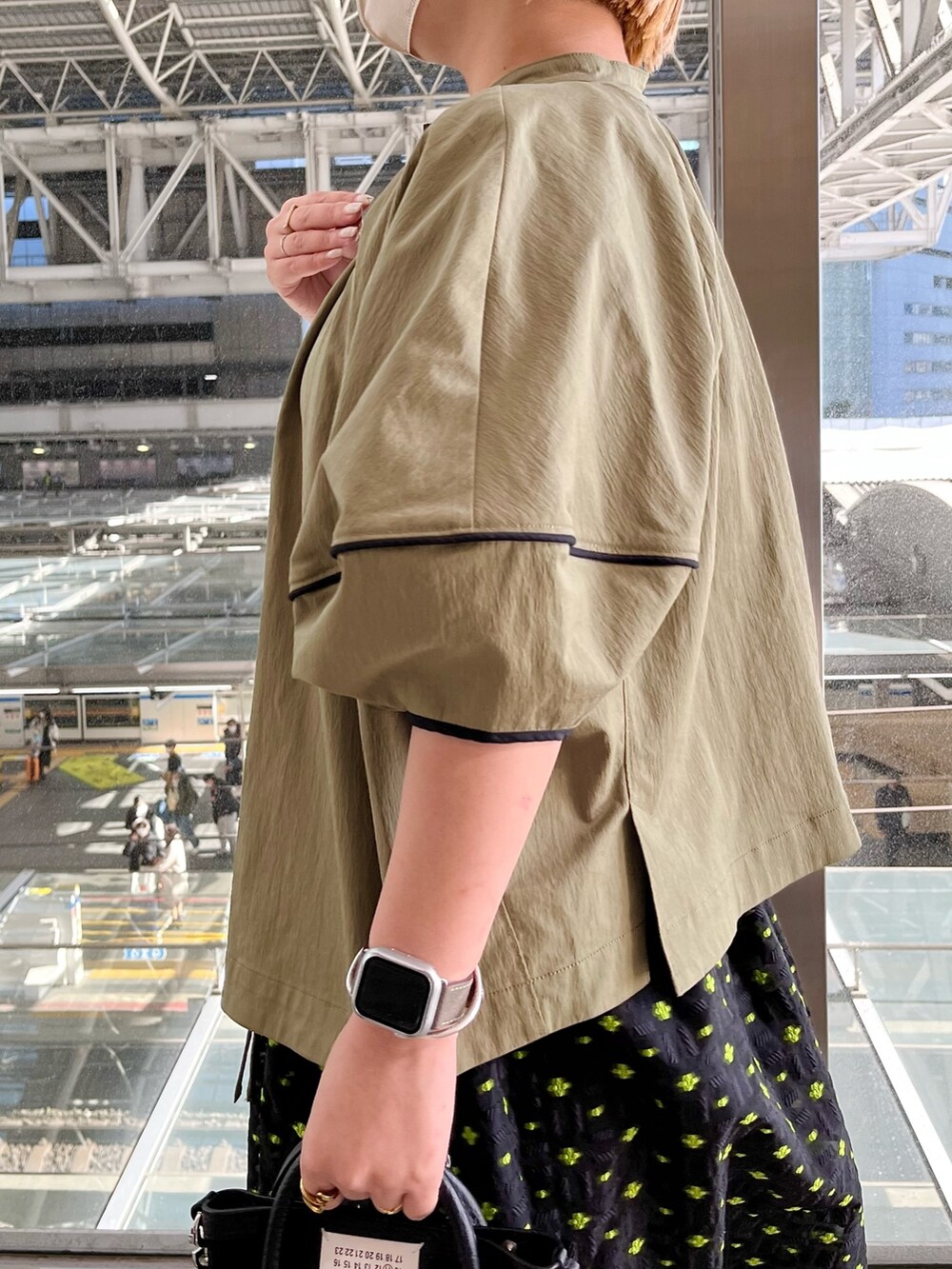 グリーン系のブルゾン、ホワイト系のタンクトップ、その他のスカートを着用したレディースの春コーディネートの5枚目の写真