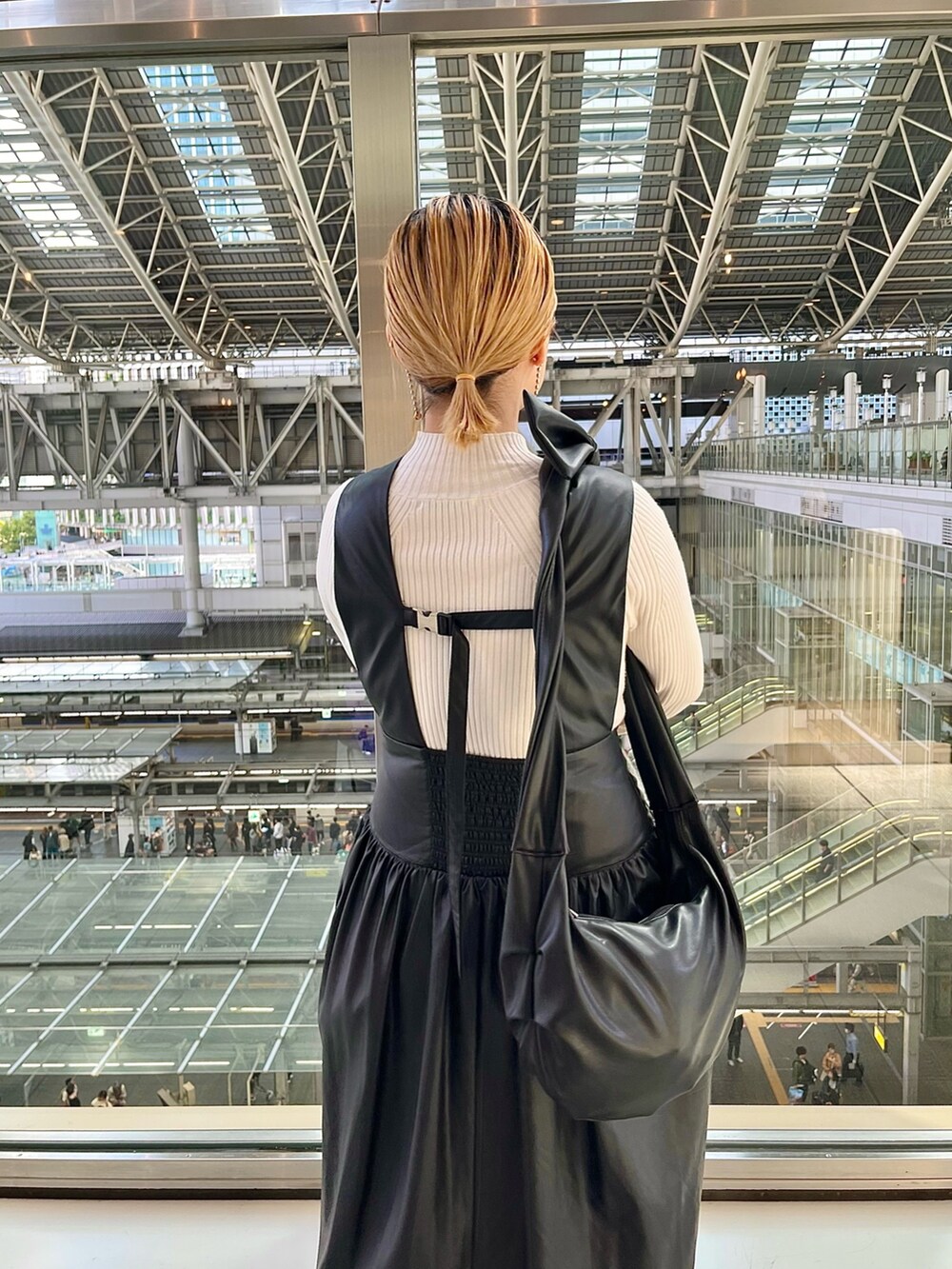 グレー系のノーカラージャケット、ブラック系のジャンパースカート、ホワイト系のニット/セーターを着用したレディースの秋コーディネートの9枚目の写真