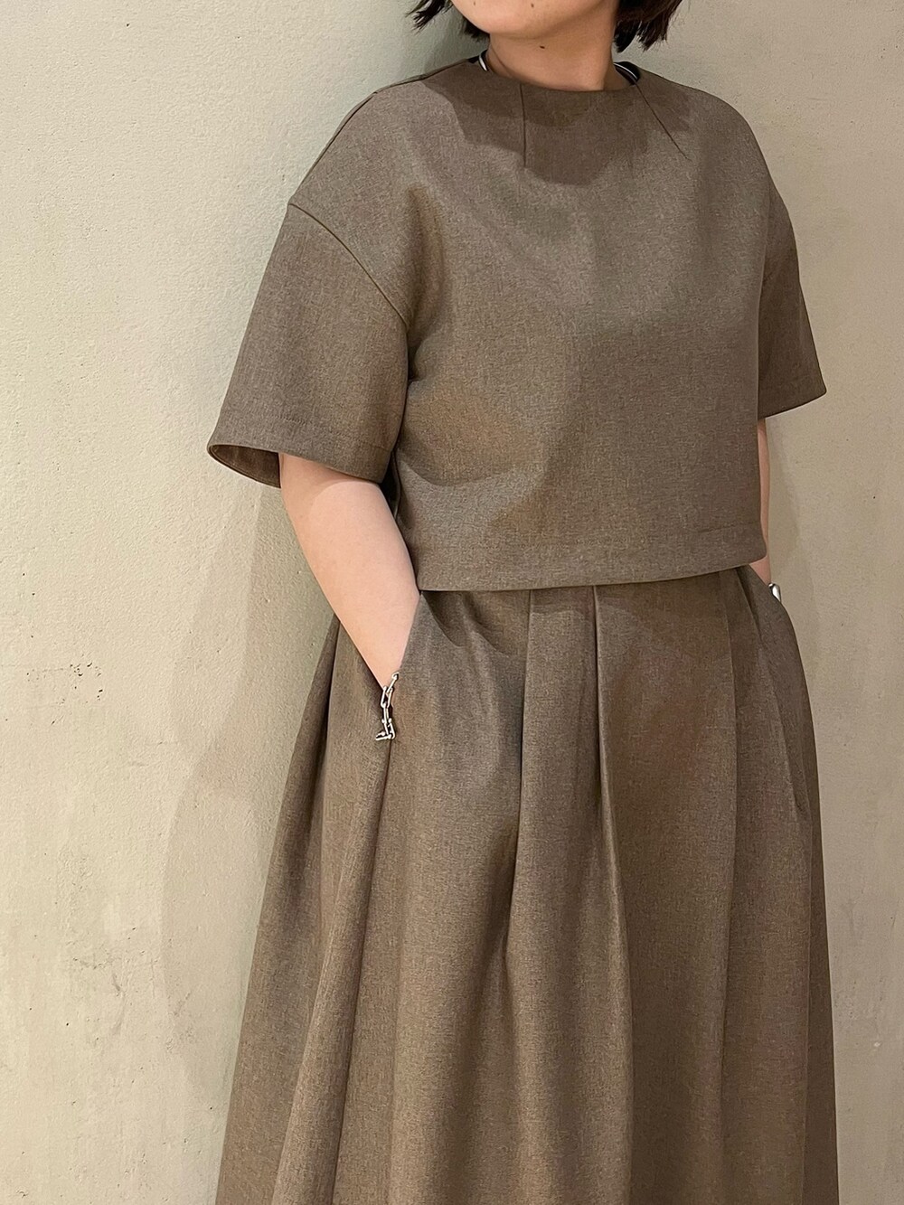 ブラウン系のスカート、ブラウン系のシャツ/ブラウス、ホワイト系のブーツを着用したレディースの春コーディネートの5枚目の写真