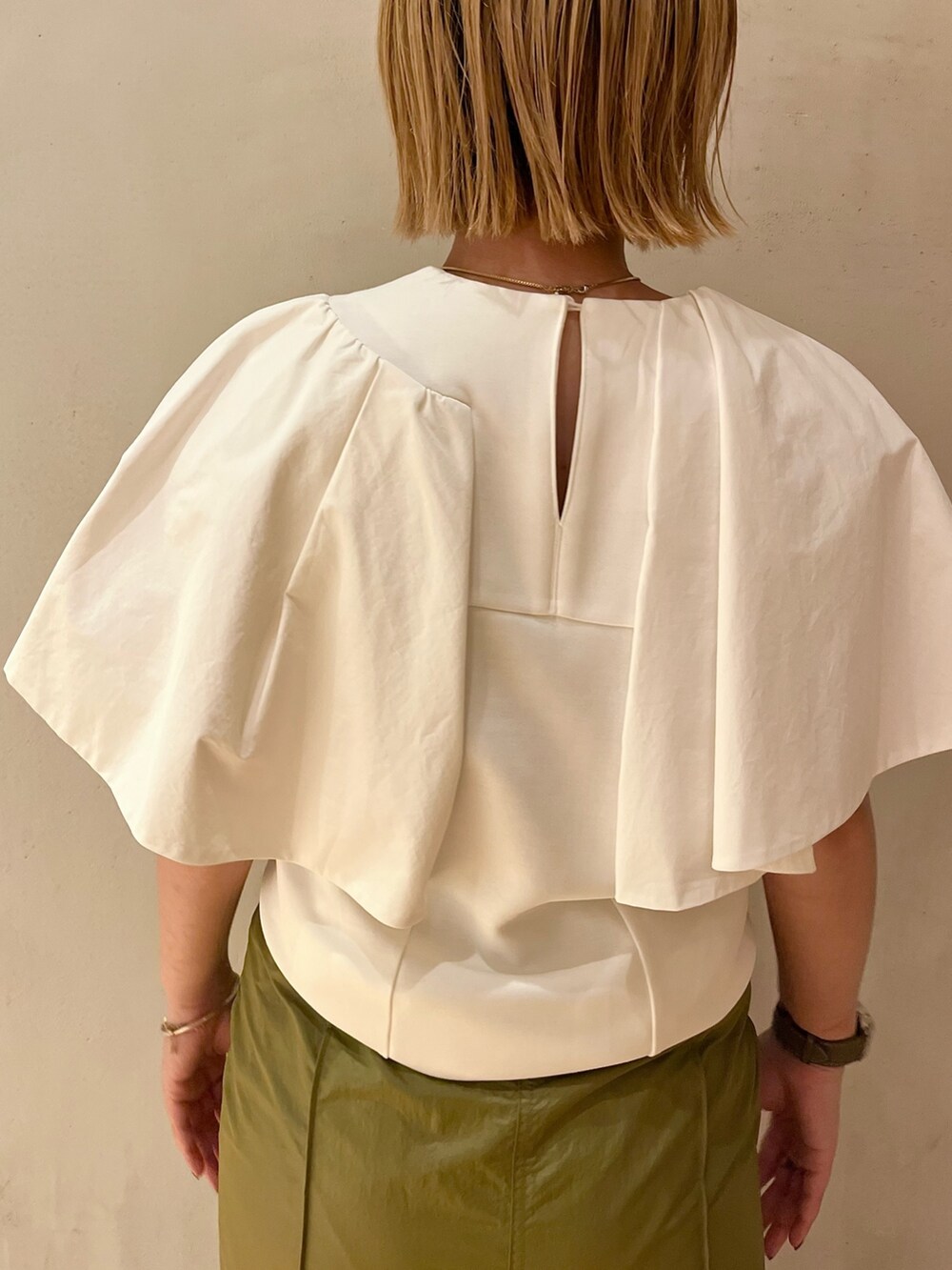 ホワイト系のTシャツ/カットソー、グリーン系のスカート、ブラック系のサンダルを着用したレディースの春コーディネートの6枚目の写真