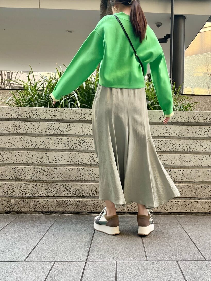 グリーン系のスニーカー、グリーン系のスカート、グリーン系のカーディガン/ボレロを着用したレディースの春コーディネートの4枚目の写真