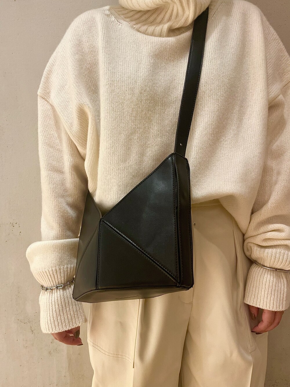 ホワイト系のニット/セーター、ホワイト系のその他パンツ、ブラック系のハンドバッグを着用したレディースの夏コーディネートの7枚目の写真