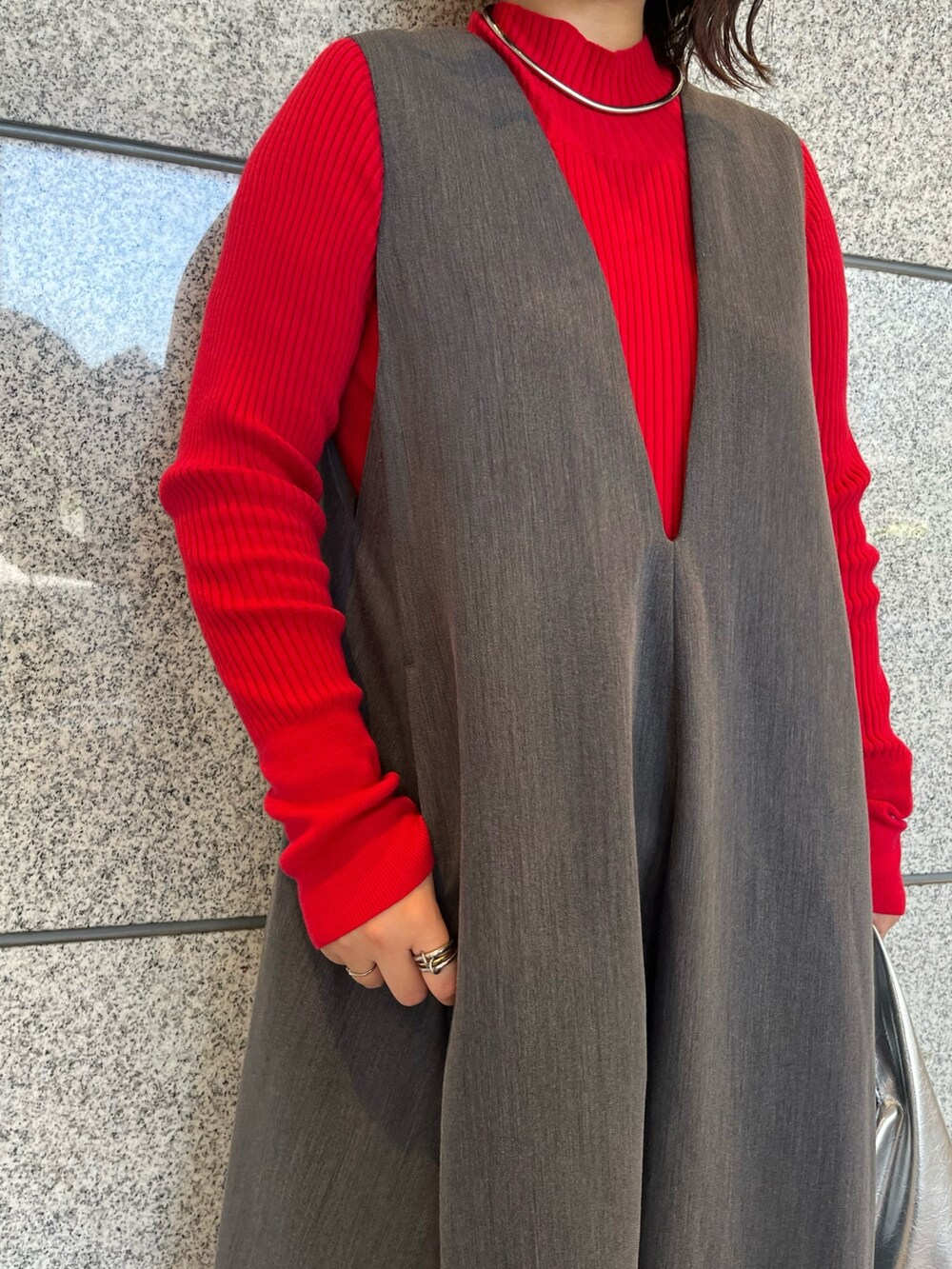 グレー系のジャンパースカート、シルバー系のブーツ、ゴールド系のハンドバッグを着用したレディースの夏コーディネートの8枚目の写真