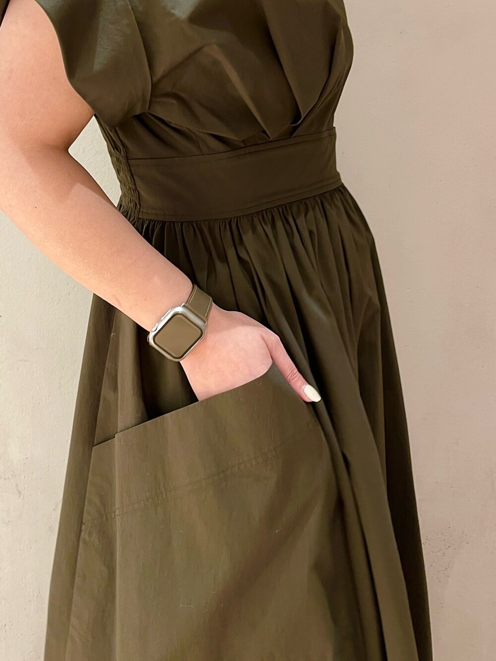 グリーン系のワンピース、ブラック系のスニーカー、シルバー系のネックレスを着用したレディースの冬コーディネートの6枚目の写真