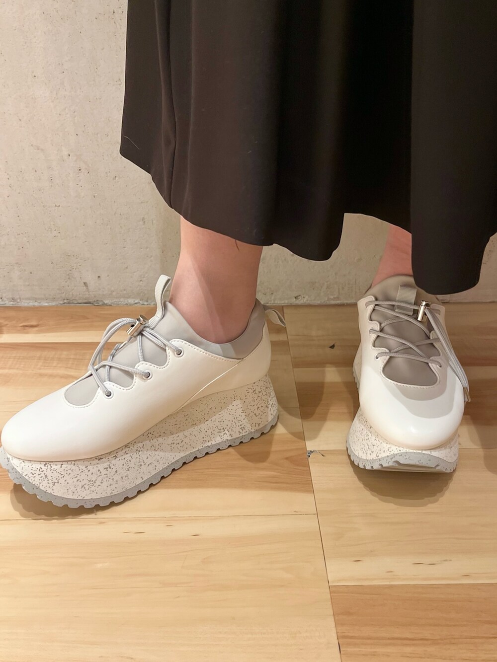 ブラック系のテーラードジャケット、ブラック系のワンピース、ホワイト系のスニーカーを着用したレディースの冬コーディネートの7枚目の写真