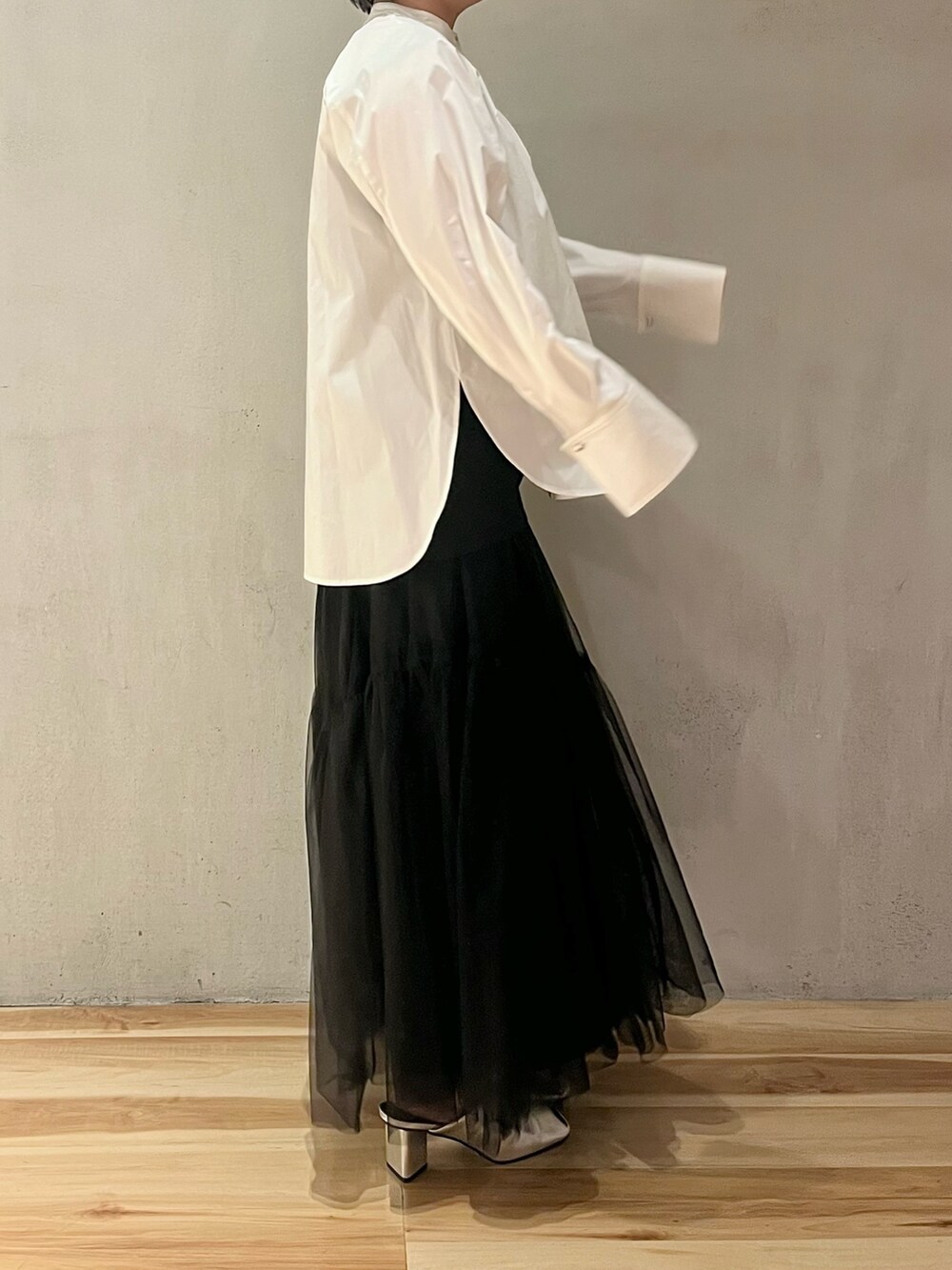 ブラック系のスカート、シルバー系のパンプス、ホワイト系のシャツ/ブラウスを着用したレディースの冬コーディネートの2枚目の写真