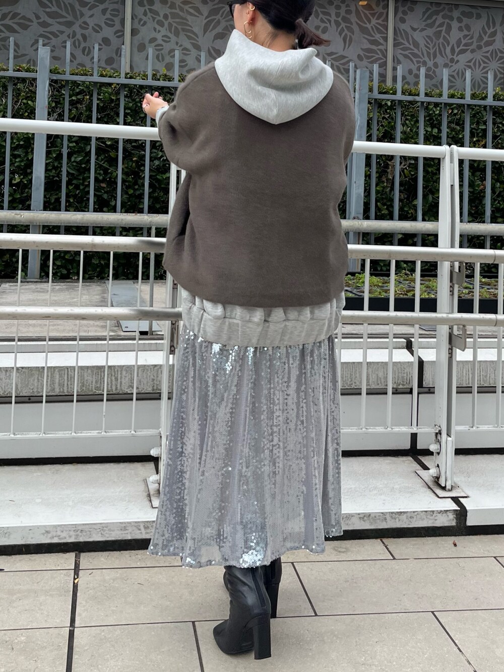 ブラウン系のカーディガン/ボレロ、グレー系のワンピース、ブラック系のブーツを着用したレディースの秋コーディネートの3枚目の写真