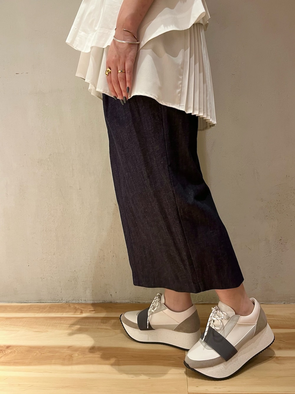 ホワイト系のシャツ/ブラウス、ブルー系のスカート、グレー系のスニーカーを着用したレディースの春コーディネートの8枚目の写真