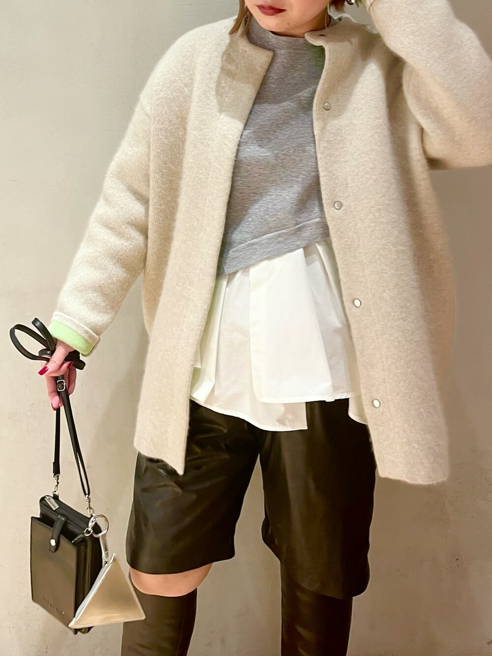 ホワイト系のカーディガン/ボレロ、グレー系のニット/セーターを着用したレディースの冬コーディネートの4枚目の写真