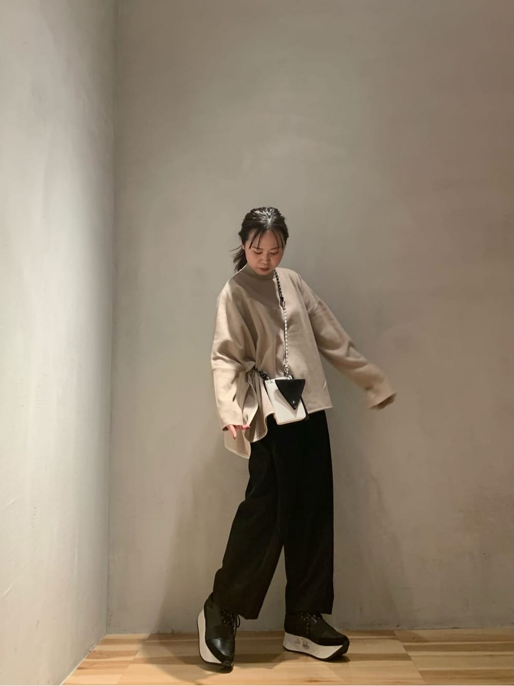 ブラック系のショルダーバッグ、ブラック系のその他パンツ、ベージュ系のニット/セーターを着用したレディースの秋コーディネートの3枚目の写真