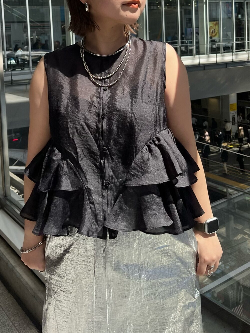 ブラック系のシャツ/ブラウス、シルバー系のスカート、ブラック系のサンダルを着用したレディースの春コーディネートの6枚目の写真