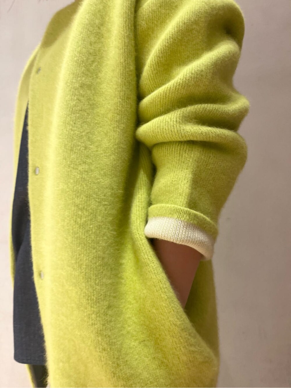 ホワイト系のショルダーバッグ、イエロー系のカーディガン/ボレロ、ブラック系のブーツを着用したレディースの秋コーディネートの4枚目の写真