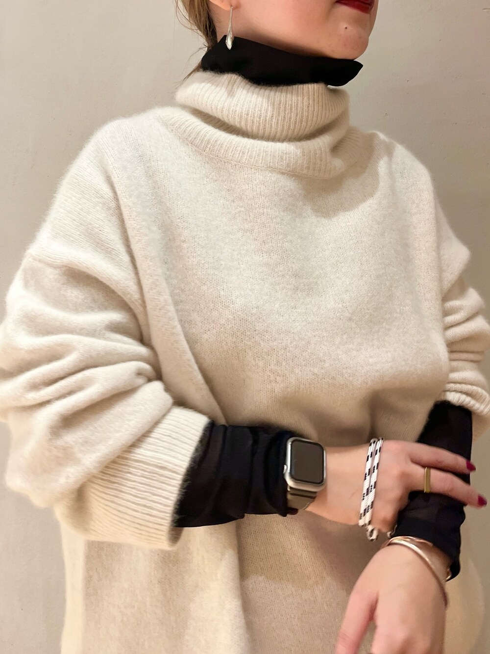 ブラック系のブーツ、ブラック系のTシャツ/カットソー、ホワイト系のニット/セーターを着用したレディースの冬コーディネートの5枚目の写真