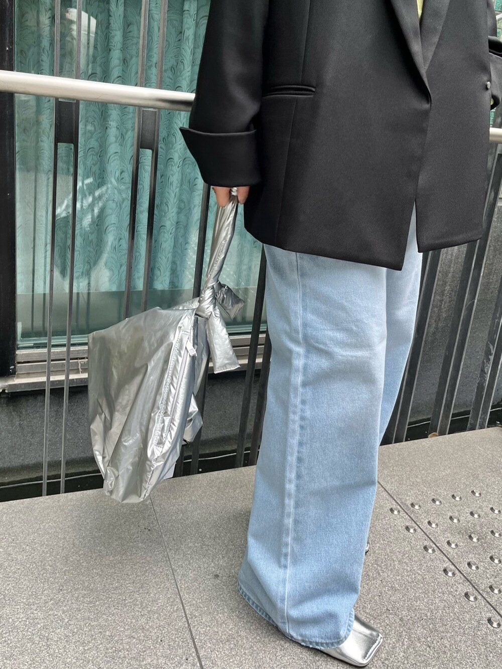 ブラック系のテーラードジャケット、イエロー系のニット/セーター、ブルー系のデニムパンツを着用したレディースの冬コーディネートの9枚目の写真