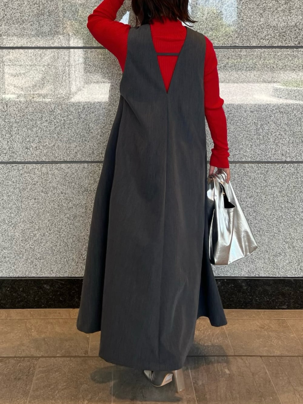 グレー系のジャンパースカート、シルバー系のブーツ、ゴールド系のハンドバッグを着用したレディースの夏コーディネートの4枚目の写真