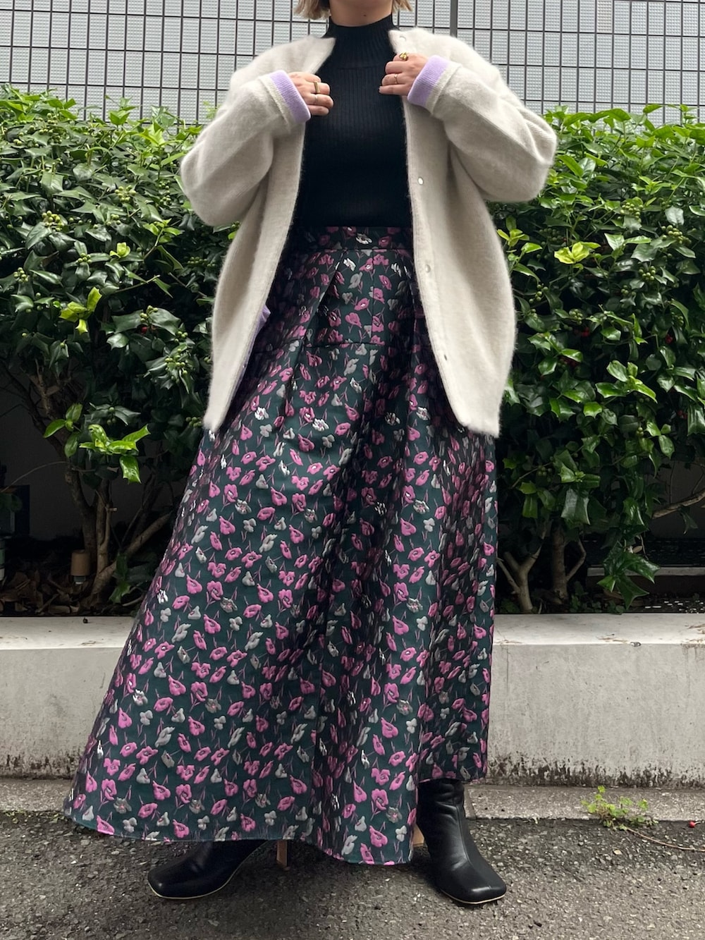 ホワイト系のノーカラージャケット、グリーン系のスカート、ブラック系のブーツを着用したレディースの夏コーディネートの5枚目の写真