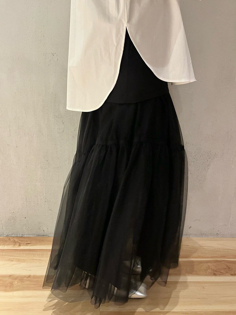 ブラック系のスカート、シルバー系のパンプス、ホワイト系のシャツ/ブラウスを着用したレディースの冬コーディネートの9枚目の写真