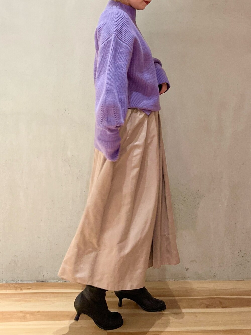 パープル系のニット/セーター、ベージュ系のスカート、パープル系のストール/ショールを着用したレディースの冬コーディネートの5枚目の写真