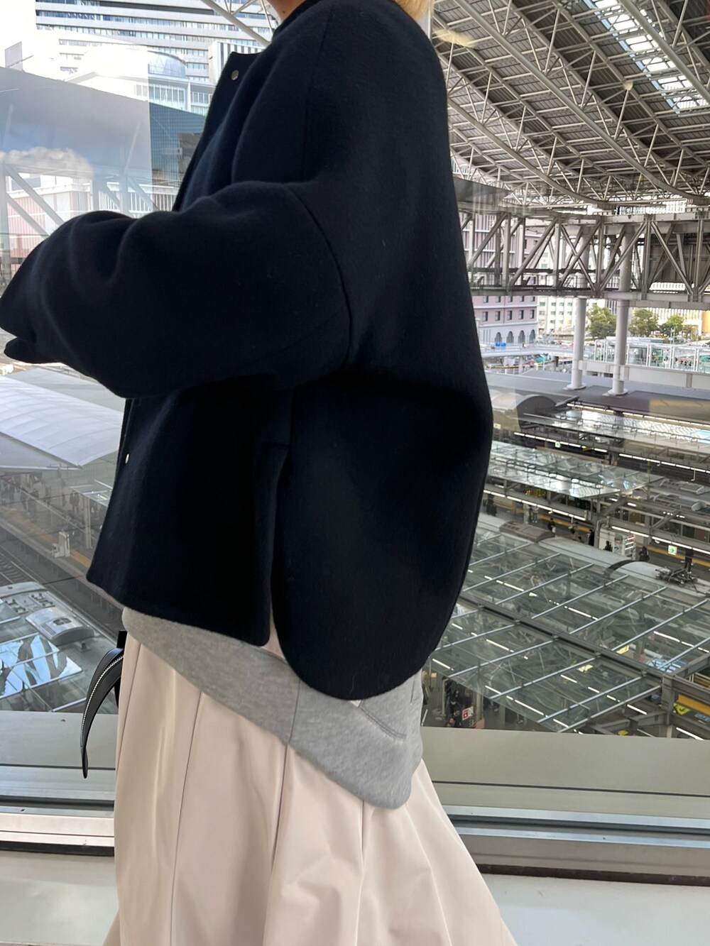 ブラック系のノーカラージャケット、グレー系のワンピース、ブラック系のハンドバッグを着用したレディースの冬コーディネートの8枚目の写真