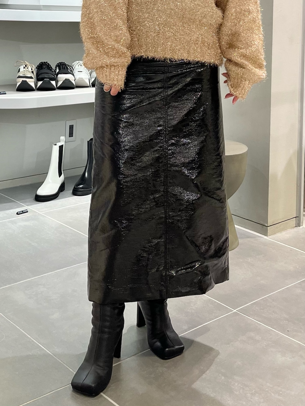 ベージュ系のニット/セーター、ブラック系のブーツ、ブラック系のハンドバッグを着用したレディースの秋コーディネートの7枚目の写真