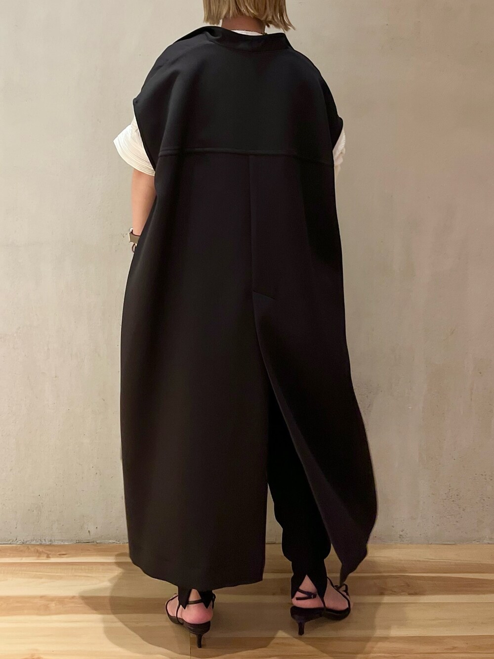 ブラック系のノーカラーコート、ホワイト系のシャツ/ブラウス、ブラック系のスラックスを着用したレディースの夏コーディネートの3枚目の写真