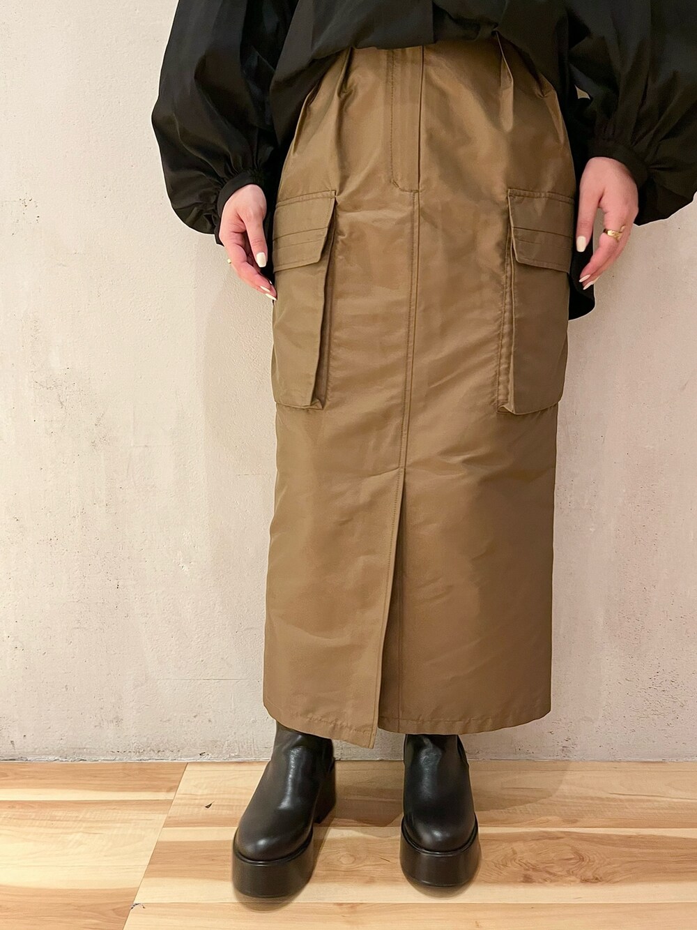 ブラック系のシャツ/ブラウス、ブラウン系のスカート、ブラック系のブーツを着用したレディースの春コーディネートの7枚目の写真